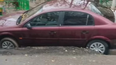 Асфальт суға шыдамады: Шымкентте бірнеше көлік шұңқырға түсіп кетті